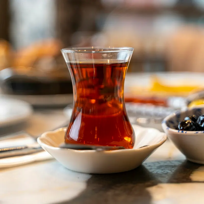 İnce belli bardakta demlenmiş çay ve tabağında kaşığı
